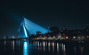 Havengezicht met industriële kranen en containers bij zonsondergang. De blik op de kade symboliseert grenzen tussen land en w